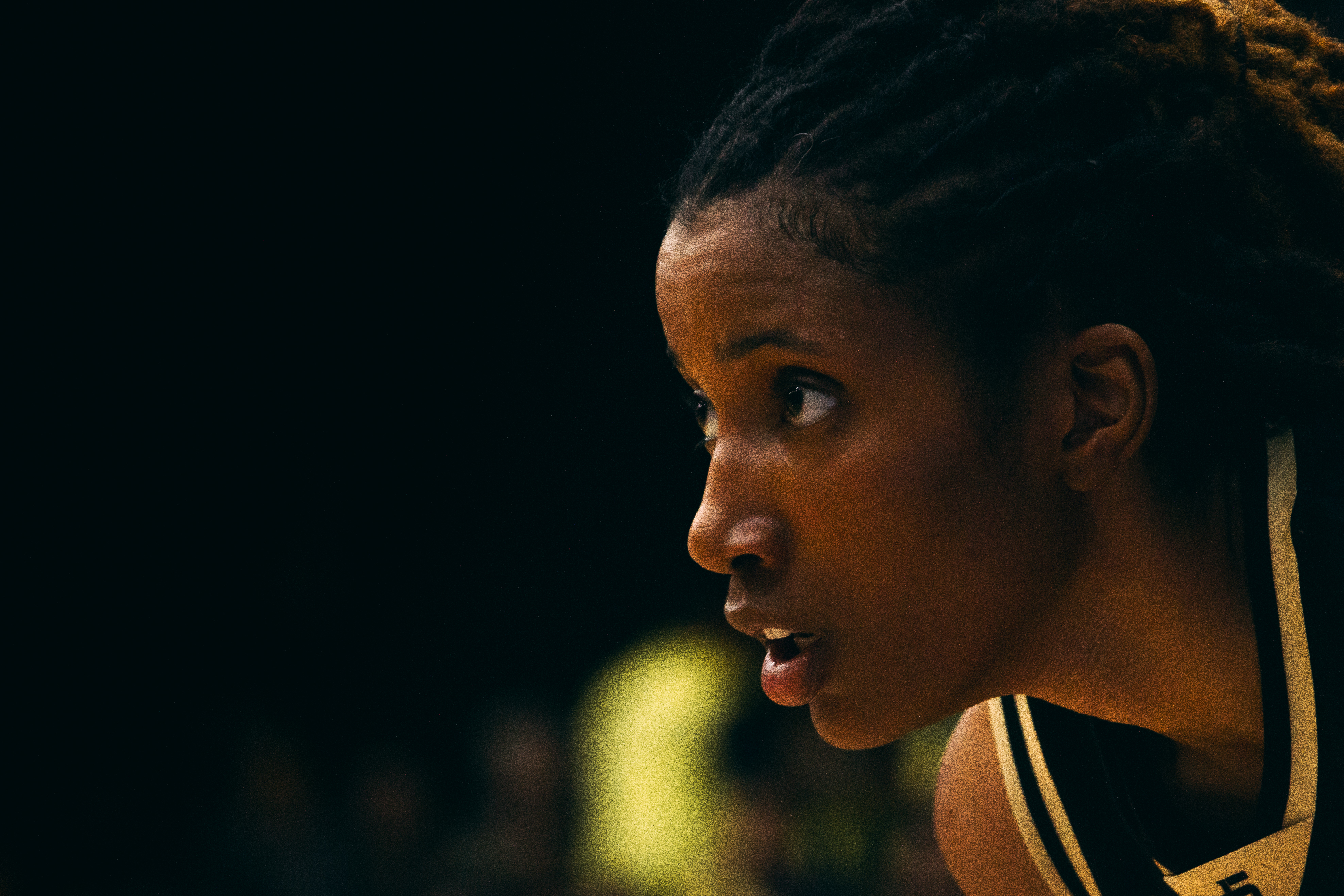 Dramatic close-up of a weightlifter's chalked hands gripping a barbell with dust particles in the air